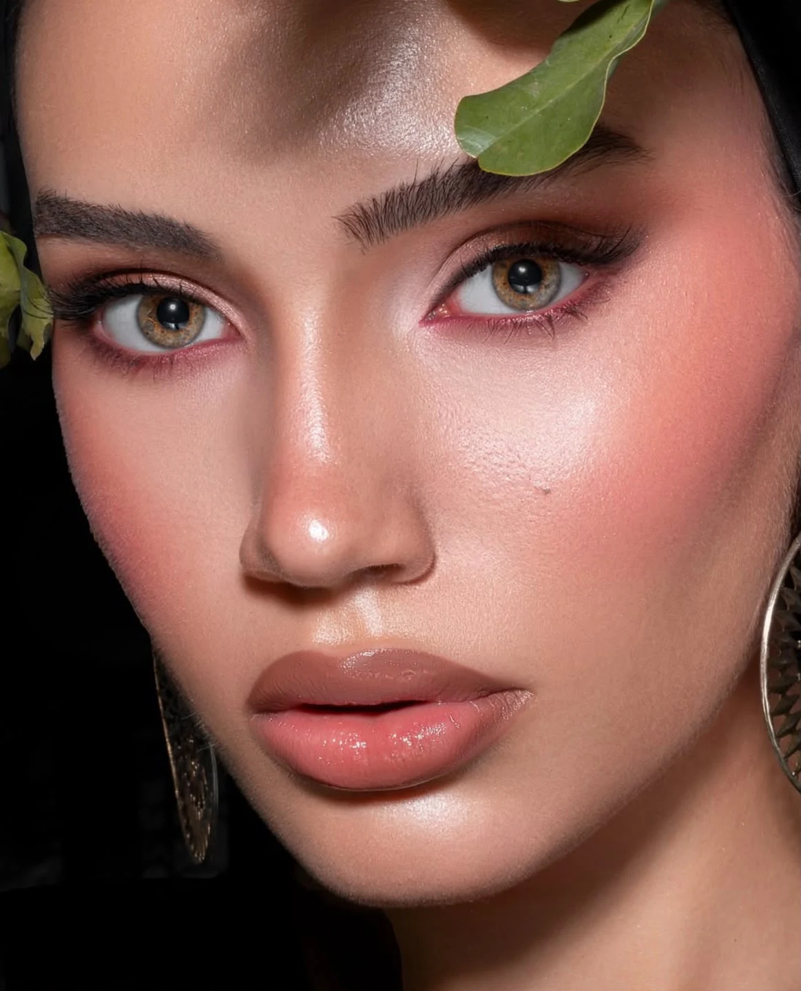 Luminous skin and rose-gold eyes in a leafy beauty portrait.