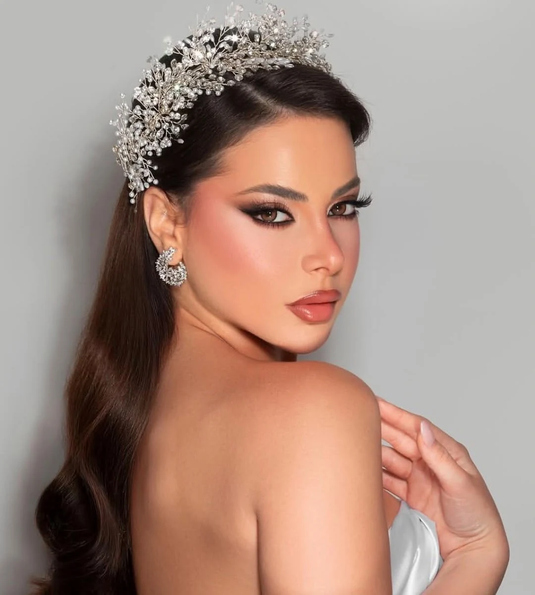 A defined bridal eye and warm nude lips with a silver crystal crown.